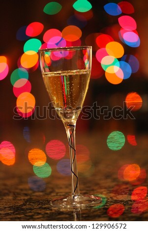 Happy New Year!!!  A glass of bubbling champagne with Christmas lights in the background.