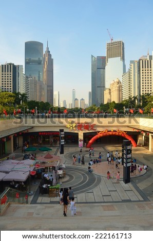 GUANGZHOU, CHINA, OCTOBER 2, 2013: People are passing by through the main shopping boulevard leading from the pearl river to tianhe in guangzhou, which is surrounded by tall skyscrapers.