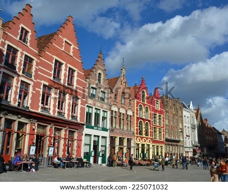 BRUGES, BELGIUM, FEBRUARY 16, 2014: People are passing by next to the traditional houses in belgian bruges.