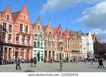 BRUGES, BELGIUM, FEBRUARY 16, 2014: People are passing by next to the traditional houses in belgian bruges.