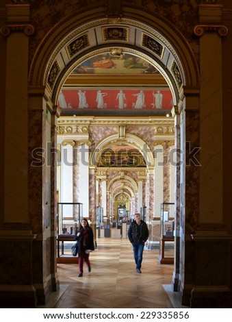 PARIS, FRANCE, MARCH 23, 2014: People are admiring masterpieces of world famous painters in louvre gallery in paris.