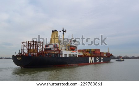 ANTWERP, BELGIUM, FEBRUARY 18, 2014: Cargo ship loaded with dozens of containers is entering port of antwerp.