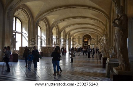 PARIS, FRANCE, MARCH 23, 2014: People are admiring masterpieces of world famous painters in louvre gallery in paris.