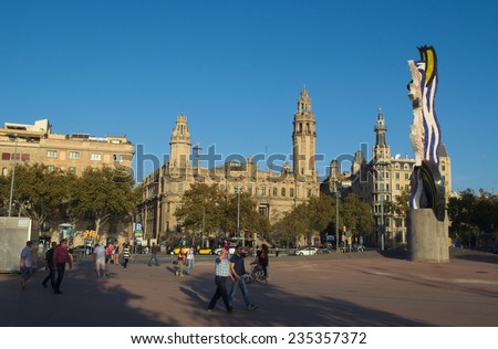 BARCELONA, SPAIN, OCTOBER 24, 2014: People are passing through the seaside square connected through passeig colom with the port vell authority.