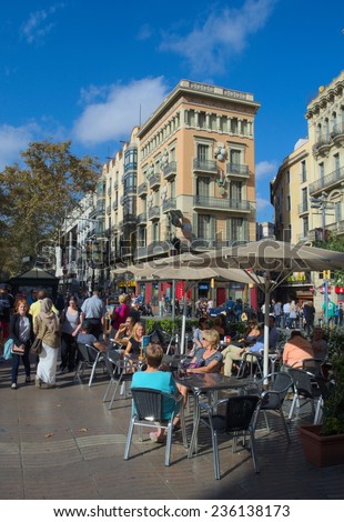 BARCELONA, SPAIN, OCTOBER 24, 2014: People are passing through iconic street in barcelona - la rambla.