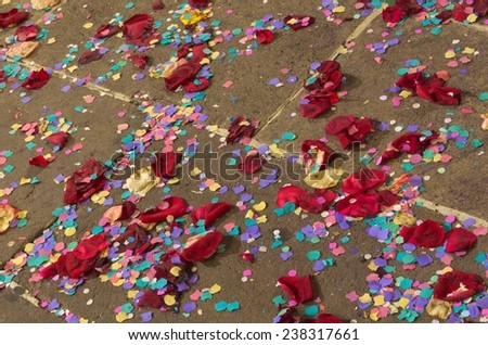 Paper confetti and rose leaves on the ground after wedding celebration.