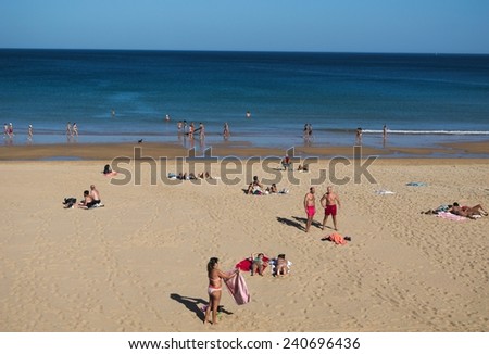 SANTANDER, SPAIN, OCTOBER 30, 2014: People are enjoying last sunny day in november on a beach in spanish coastal town santander.