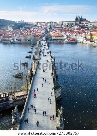 people are trying to cross charles bridge in prague in order to get to the famous prague castle, hradcany district and church of saint nicolas which are situated on the opposite shore of vltava