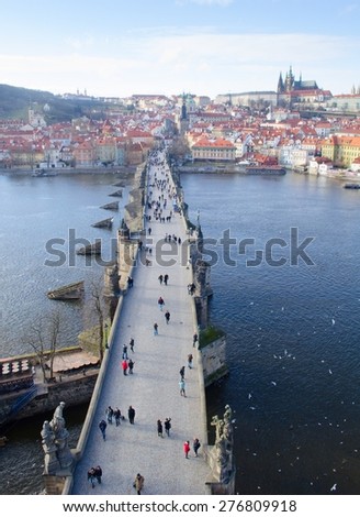 people are trying to cross charles bridge in prague in order to get to the famous prague castle, hradcany district and church of saint nicolas which are situated on the opposite shore of vltava