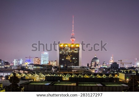 view of berlin skyline taken from the terrace of reichstag during night. fernsehturm is hidden behind a shopping center.