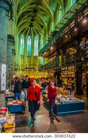 MAASTRICHT, NETHERLANDS, APRIL 12, 2014: People are buying books in bookshop which is situated in former church in maastricht.