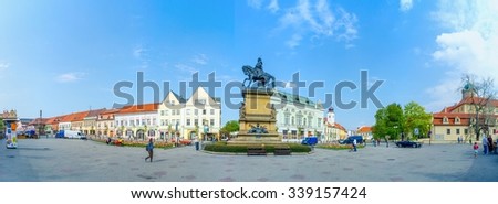 PODEBRADY, CZECH REPUBLIC, APRIL 28, 2015: people are strolling through the main square of czech city podebrady which is dominated by statue of the czech king jiri z podebrad.