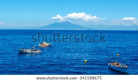 people are waiting on various boats in order to get into the famous grotta azzura situated on capri island in the bay of naples.