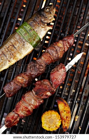 Meat and fish shashlik on grill