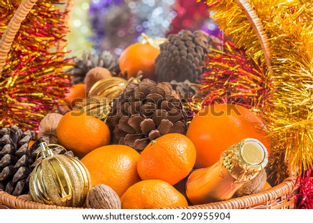Christmas basket with fruit, pine cones and a bottle of wine is reflected in a mirror