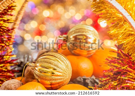 Gold Christmas ball in the basket with fruits and nuts is reflected in the mirror