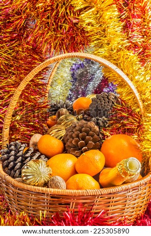 Christmas basket with fruit, pine cones and a bottle of champagne is reflected in a mirror