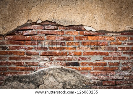 Cracked wall with orange bricks inside