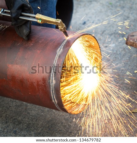 Worker cut big pipe with spark light