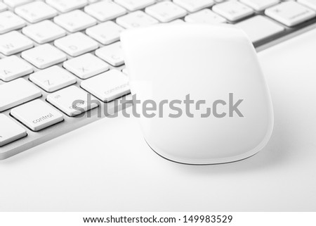 White mouse over keyboard on white background