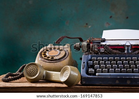 Old English type writer with paper sheet and telephone, still life