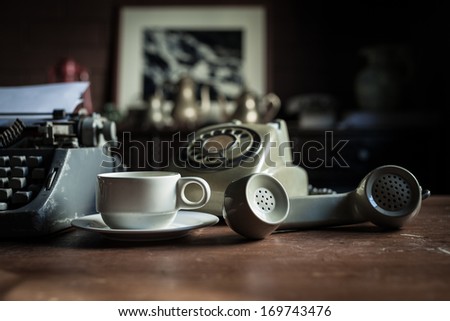 Still Life Of Retro Office, Telephone, Typewriter And Coffee Cup Placed Near Old Lamp On Wooden Table