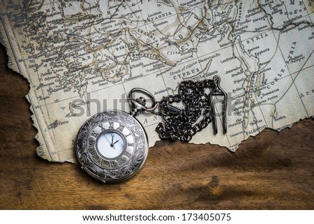 Vintage pocket watch on burnt ancient map