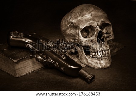 Still life, skull with ancient gun and old book on map