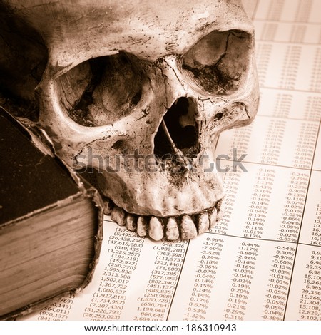 still life with human skull black pencil and finance report