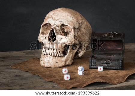 Still life with human skull, dices and leather box