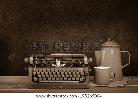 Still life, old typewriter and vintage teapot on wooden desk