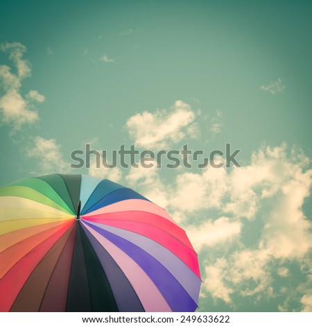 Rainbow umbrella on sky background, vintage style