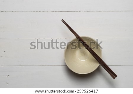 empty bowl with chop sticks on wooden white table