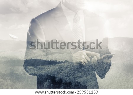 Double exposure of satellite dish on the hill and business man using smart phone
