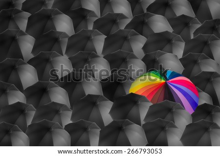 rainbow umbrella in mass of black umbrellas, different concept
