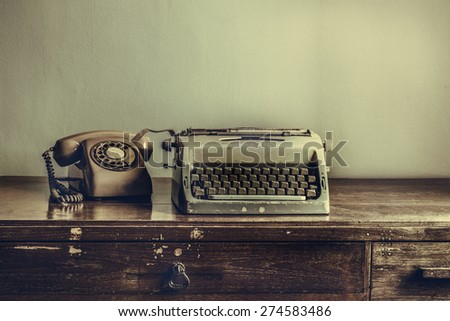 Vintage typewriter, telephone,on table desaturated photo