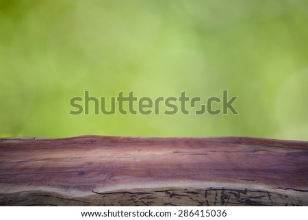 background of log wood table and green garden of spring time