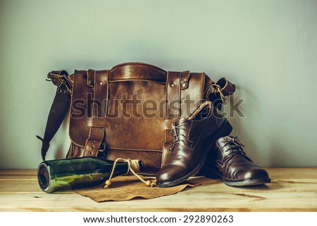 Still life with leather suitcase, brown shoes, and old glasses on the book, vintage style