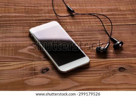 listen the music, smart phone on the table with earphones