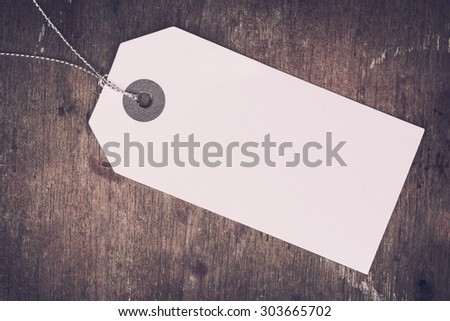 Blank white paper tag on wood surface