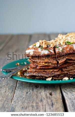 Pancake Pie from the Liver with Walnuts in the Green Plate on Wooden Table