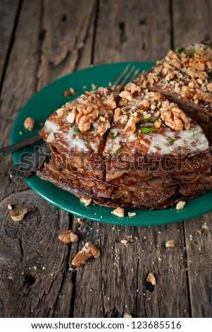 Pancake Pie from the Liver with Walnuts in the Green Plate on Wooden Table