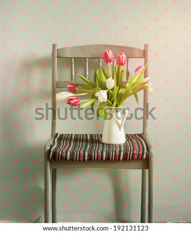 Pink Tulips on a Chair, Flowers in Spring Composition on Grey Wall with Pink Pears. seasonal home interior