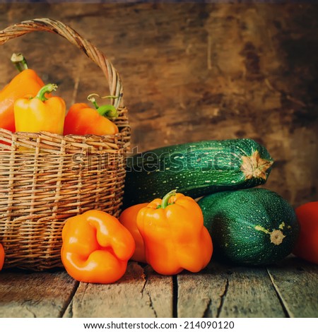 Organic Pepper and Vegetable Marrow in Country Basket on Wooden Background, still life