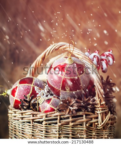 Fairy Tale Christmas Composition with Vintage Gifts in basket. With red balls, pine cones and sweets. Drawing snow, toned effect