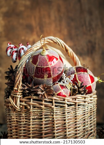 Country Christmas Composition with gifts. Basket, red balls, pine cones, sweets. Vintage style