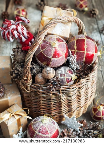 Vintage Christmas Gifts in Magic Composition with Basket. Red balls, Pine cones, Sweet Candy, Pine cones, Boxes, Walnuts and snowflakes. Country style