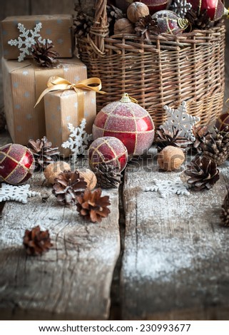 Christmas Gifts with Basket, Red balls, Pine cones, Boxes, Snowflakes, Pine cones on Wooden Table. Vintage style