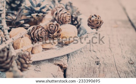 Toned Image of Christmas Tray with Holiday decoration. Pine cones, Walnuts, Almonds, Nuts on Wooden Background
