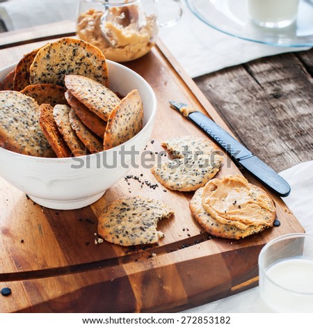 Cracker Cookies with Black Sesame Seeds and Peanut Butter as breakfast on the wooden chopping board